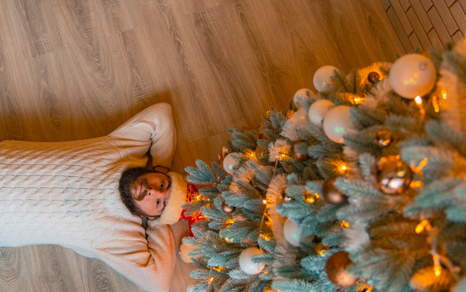 man on floor under Christmas tree