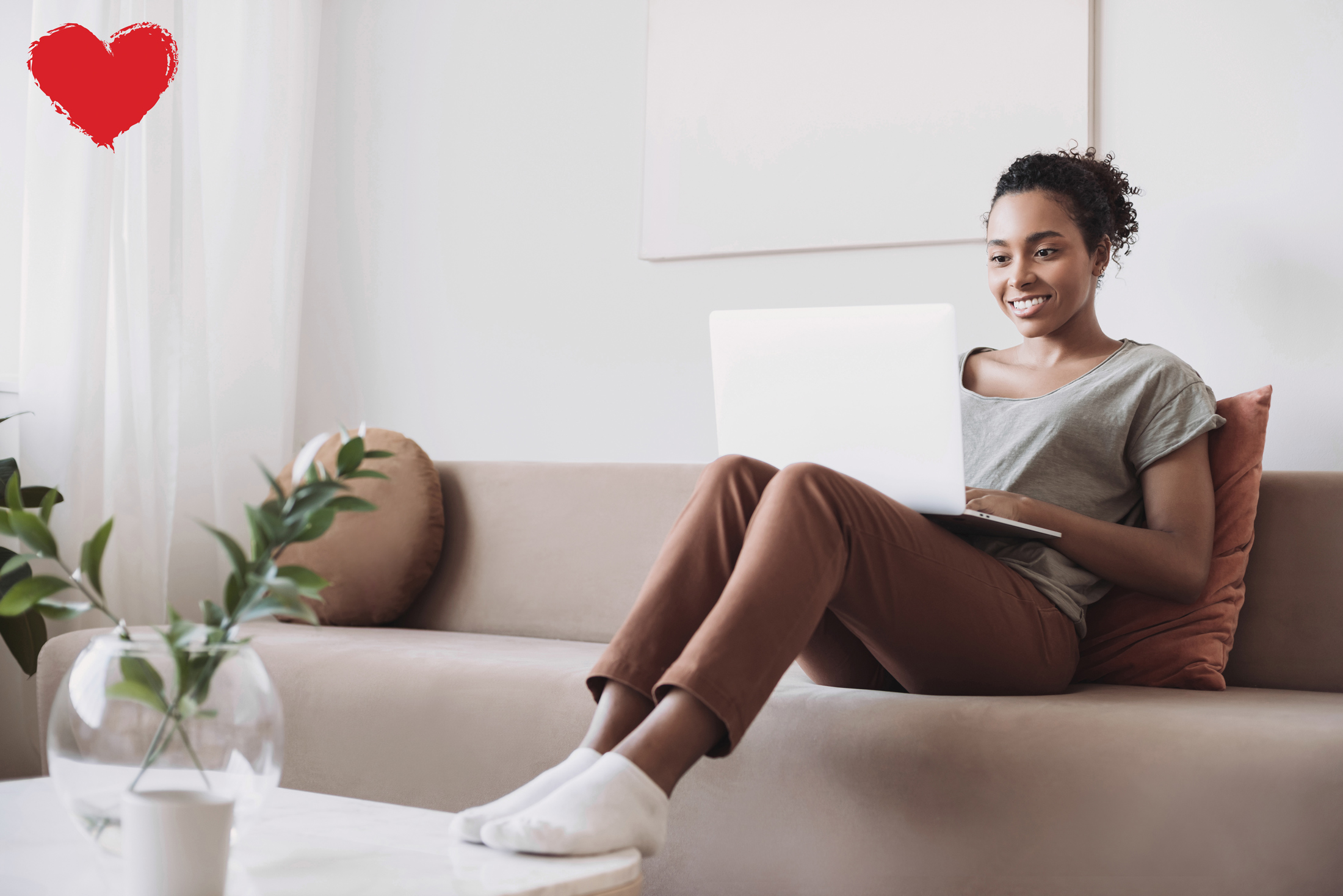 young black woman doing telehealth from couch on laptop